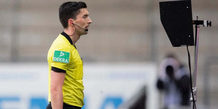 Schiedsrichter Florian Badstübner schaut sich eine Szene im Videobeweis an.