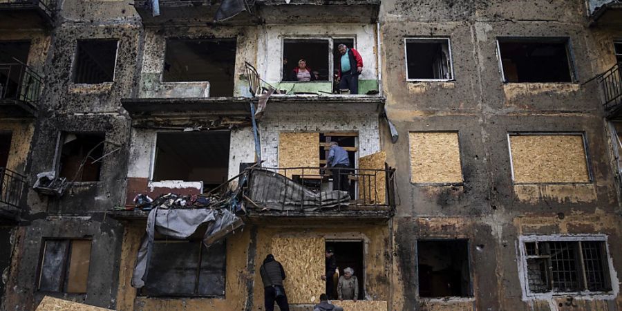 Anwohner schliessen die Fenster eines Wohnhauses mit Sperrholz nach russischem Beschuss in Dobropillja in der Region Donezk in der Ostukraine. Foto: Evgeniy Maloletka/AP/dpa