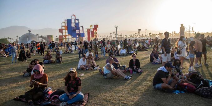 Festivalbesucher sitzen auf dem Gelände des Coachella-Festivals 2022. Festivalbesucher sitzen auf dem Gelände des Coachella-Festivals 2022.