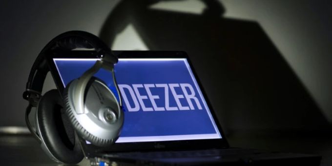 Kopfhöher und Laptop mit dem Deezer-Logo Kopfhöher und Laptop mit dem Deezer-Logo