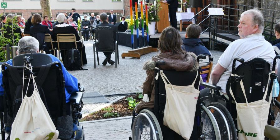 Mit einem Gottesdienst auf dem Platz vor der Oberlinkirche gedenken Bewohner, Angehörige und Gäste der vier Bewohner eines Potsdamer Wohnheims für behinderte Menschen, die vor einem Jahr ermordet wurden. Eine Pflegekraft verübte die Morde.