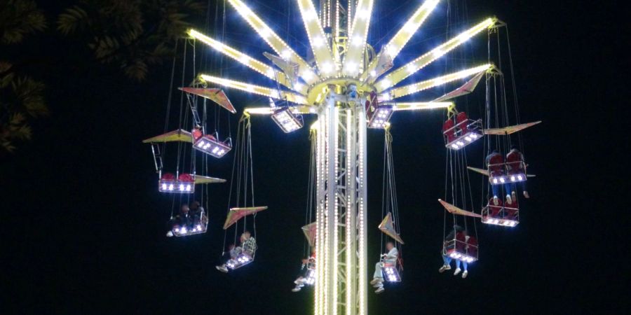 Besucher sitzen in 25 Metern Höhe in einem Kettenkarussell auf einem Volksfest in Aachen.