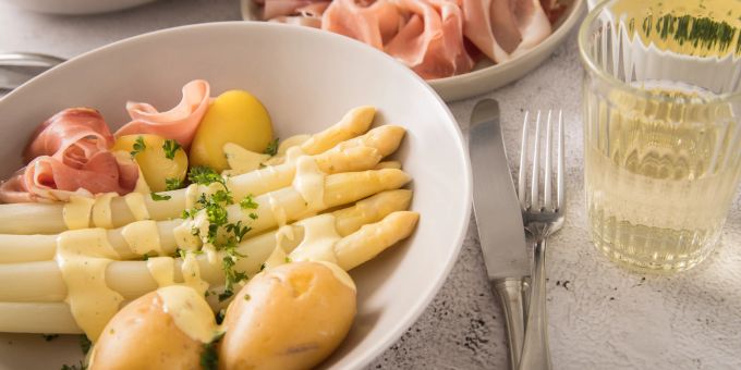 Toll auf dem Teller, lästig beim Gang auf die Toilette: Spargel sorgt nicht selten dafür, dass der Urin streng riecht. Spargel Kartoffel Schinken Wein Besteck Tisch Teller