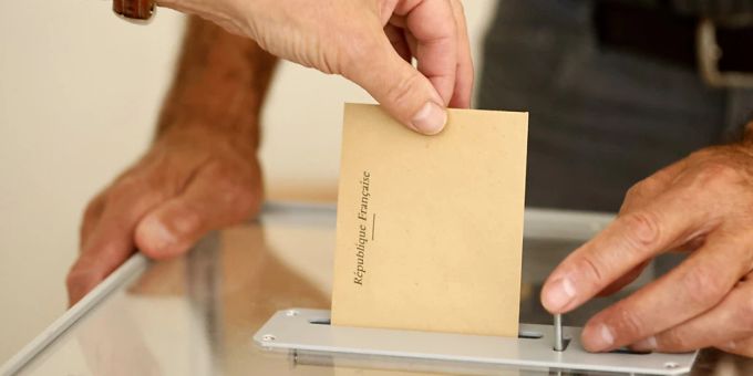 Ein Wähler wirft in einem Wahllokal seinen Stimmzettel in eine Wahlurne. Die Französinnen und Franzosen wählen ein neues Parlament. Foto: Jean-Francois Badias/AP/dpa Ein Wähler wirft in einem Wahllokal seinen Stimmzettel in eine Wahlurne. Die Französinnen und Franzosen wählen ein neues Parlament. Foto: Jean-Francois Badias/AP/dpa
