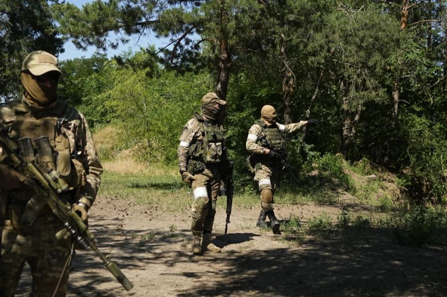 Russische Soldaten gehen an einem eroberten ukrainischen Kontrollpunkt mit gut befestigten Gräben in der Nähe der Stadt Schastia.