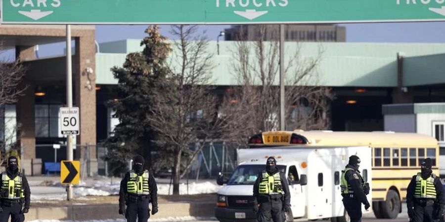 Polizisten vor der Ambassador-Brücke in Windsor. Die kanadische Polizei hat mit der Auflösung von Trucker-Blockaden an einer wichtigen Grenzbrücke zwischen der Stadt Windsor in Kanada und Detroit in den USA begonnen. Foto: Nathan Denette/The Canadian Press/AP/dpa