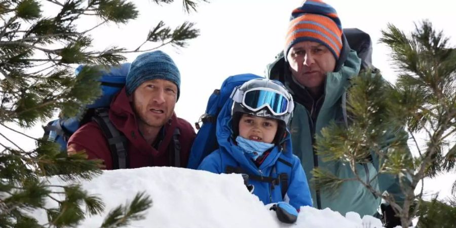 Flora (Yuna Bennet, m.) bringt Martin (Hans Sigl, r) und seinen Bruder Hans (Heiko Ruprecht) zu der Stelle, an der ihre Skilehrerin abgestürzt ist. Foto: Barbara Bauriedl/ZDF/dpa