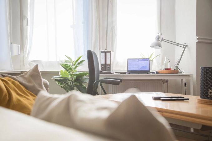 Im Homeoffice spielte sich das Leben für viele Beschäftigte monatelang ab: Jetzt gilt es sich zumindest teilweise wieder ans Büroleben zu gewöhnen. Sofa Schreibtisch Laptop Fenster Aktenordner