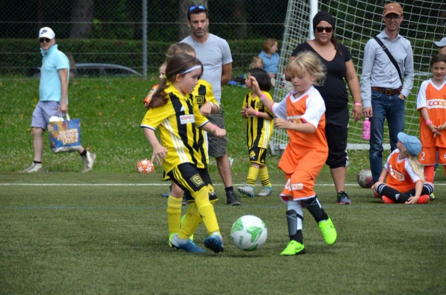 Kleine Mädchen spielen Fussball.