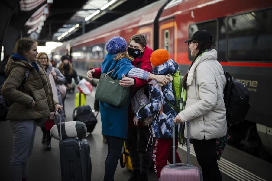 Ein junger Mann aus der Ukraine umarmt eine Bekannte am Hauptbahnhof Zürich.