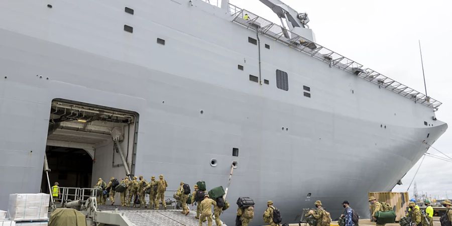 HANDOUT - Soldaten betreten im Hafen von Brisbane die HMAS Adelaide bevor sie nach Tonga abreisen. Foto: Robert Whitmore/ADF/AP/dpa - ACHTUNG: Nur zur redaktionellen Verwendung im Zusammenhang mit der aktuellen Berichterstattung und nur mit vollständiger Nennung des vorstehenden Credits