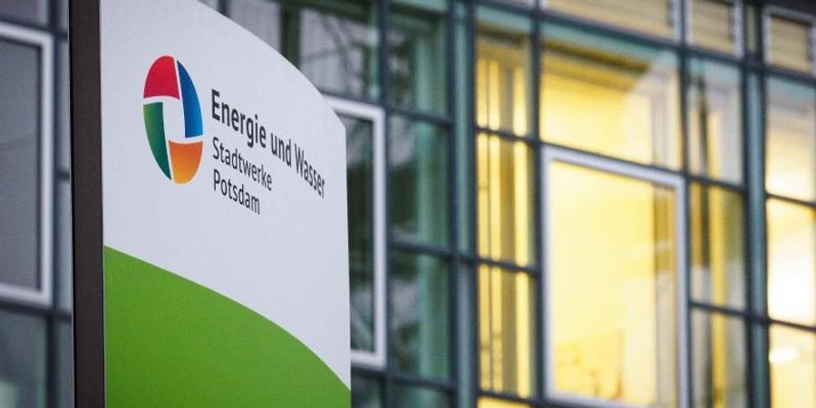 Ein Schild mit der Aufschrift «Energie und Wasser» steht vor beleuchteten Büros am Eingang zu den Potsdamer Stadtwerken. Foto: Soeren Stache/dpa-Zentralbild/dpa