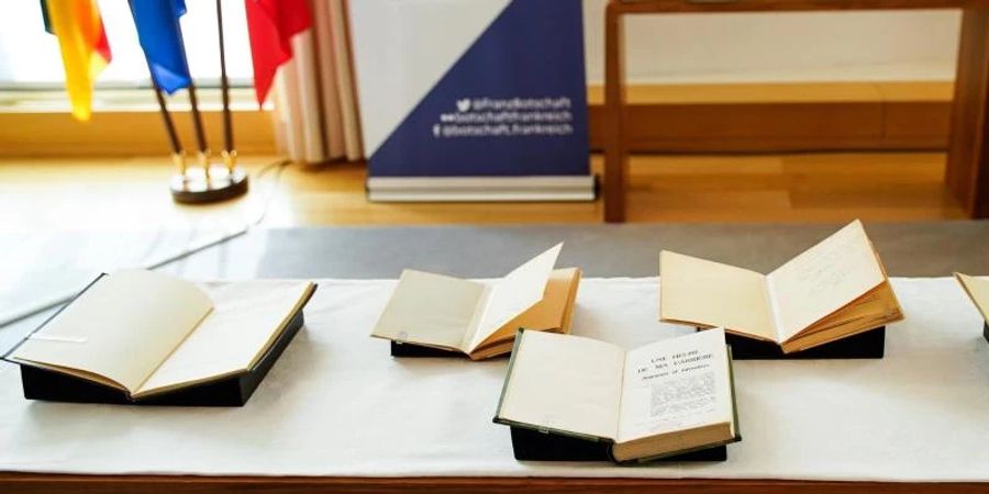 Bücher liegen auf einem Tisch der französischen Botschaft in Berlin. Sie waren im Zweiten Weltkrieg von deutschen Truppen beschlagnahmt worden. Foto: Monique Ulrich/Französische Botschaft in Deutschland/dpa