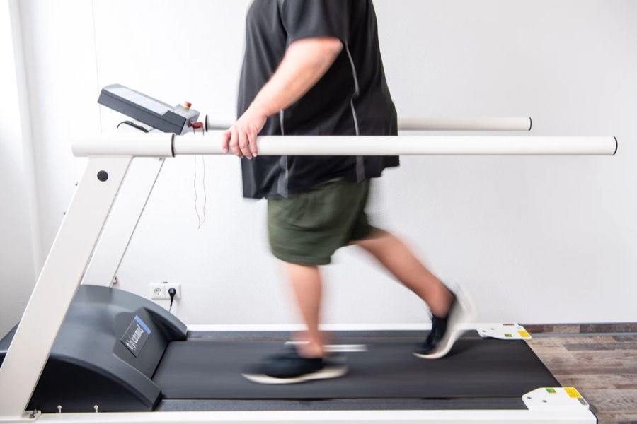 Ein Mann trainiert an einem Laufband, um seine Ausdauer nach einer Coronainfektion zu stärken.