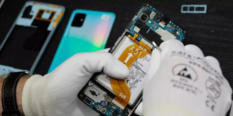 Reparatur eines Mobiltelefones in der Werkstatt der Komsa AG. Verbraucherschützer fordern die Bundesregierung dazu auf, das geplante Recht auf Reparatur bis Mitte März auf den Weg zu bringen. Foto: Sebastian Willnow/dpa-Zentralbild/dpa