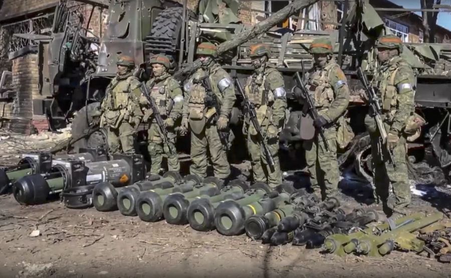 Ukraine Krieg: Russische Soldaten posieren vor Panzer- und Flugzeugabwehrwaffen, die Ukrainer in Donezk zurückgelassen haben.