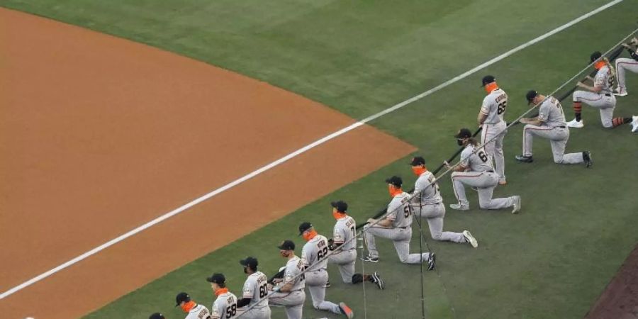 Die Spieler San Francisco Giants knien während einer Schweigeminute vor dem MLB-Eröffnungsspiel. Foto: Mark J. Terrill/AP/dpa