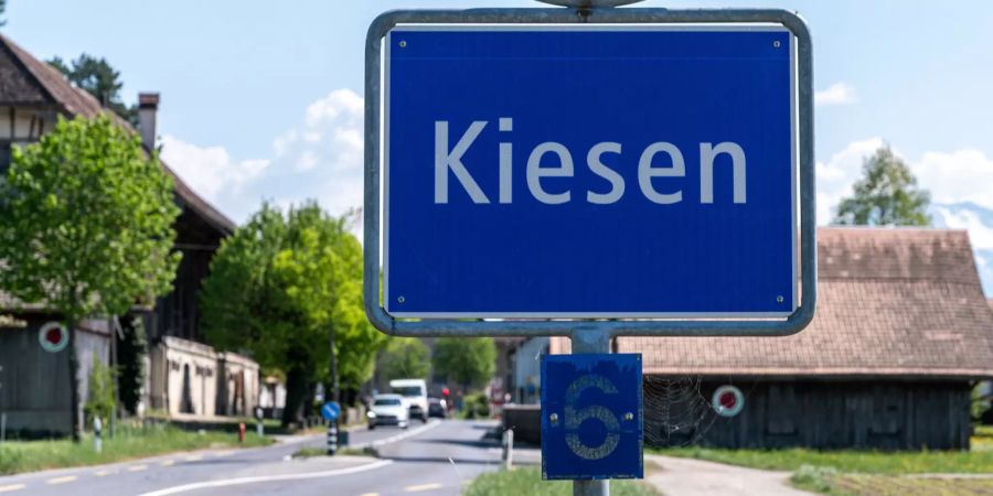 Kantonsstrasse mit Ortsschild von Kiesen.