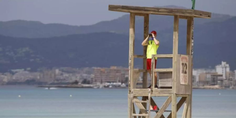 Ein Rettungsschwimmer beobachtet den Strand von Arenal. Foto: Clara Margais/dpa