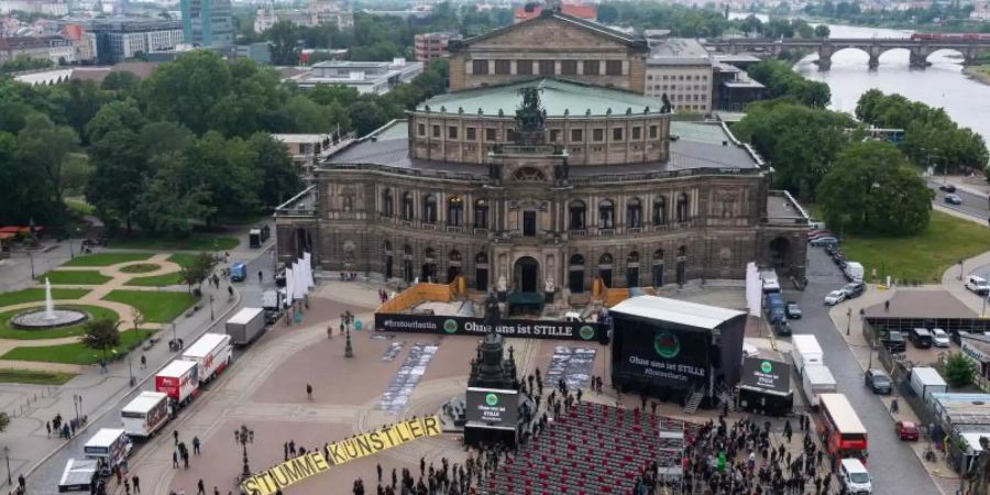 «Ohne uns ist Stille» - eine Aktion mit 1000 leeren Stühlen und 1000 Personen. Foto: Robert Michael/dpa-Zentralbild/dpa