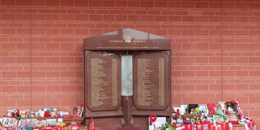 Blumen, Bilder und Schals liegen in Gedenken an die Opfer der Hillsborough-Katastrophe in Liverpool. Foto: Peter Byrne/PA Wire/dpa