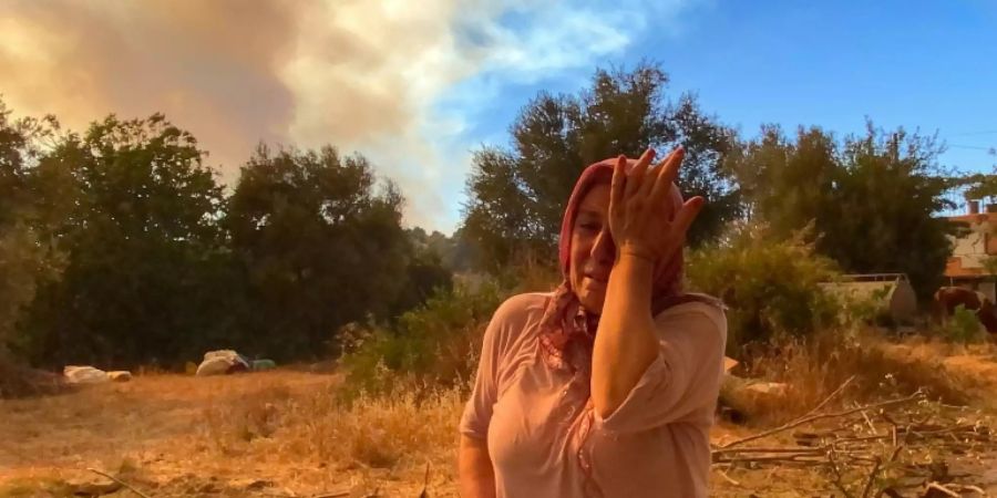 Verzweifelte Frau vor der Kulisse der Waldbrände in der Südturkei