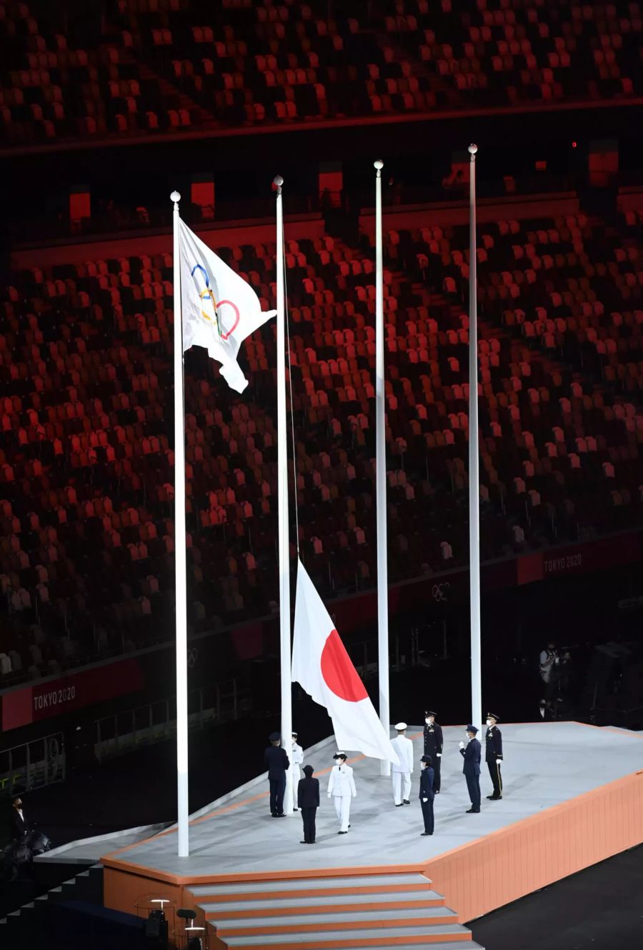 Die Olympische und die japanische Flagge werden gehisst.