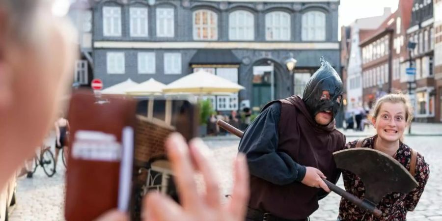 In seiner braunen Kutte führt der Scharfrichter Meister Hans durch die Altstadtgassen von Lüneburg. Foto: Philipp Schulze/dpa