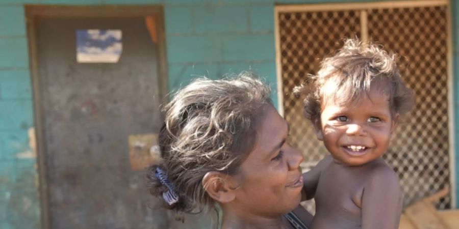 ARCHIV - Eine Frau und ein Kind spielen am 24.07.2017 in Ramingining im Northern Territory (Australien) während Bauarbeiten an ihrem Zuhause beginnen. Die Bauarbeiten sind Teil eines 10-Jahres-Plans der australischen Regierung, wodurch der Überbevölkerung in Aborigines-Gemeinden entgegengewirkt werden soll. Foto\ Lucy Hughes Jones/AAP/dpa +++(c) dpa - Bildfunk+++ Foto: Lucy Hughes Jones/AAP/dpa