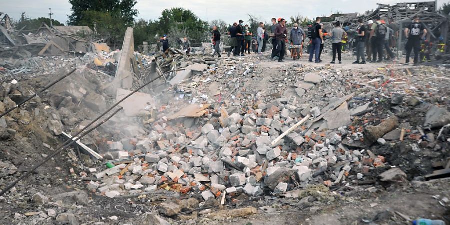 Helfer beseitigen Trümmer an einem Krater nach einem Luftangriff. Russlands Armee hat nach ukrainischen Angaben mit mehreren Raketen Wohnhäuser bombardiert und zahlreiche Zivilisten getötet. Foto: ---/ukrin/dpa