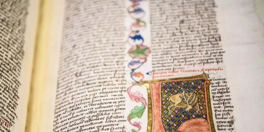 Eine Seite in einer Mainzer Bibel (ca. 1500 Jh.), mit einer Bordüre und Plattgoldelementen gestaltet. Foto: Andreas Arnold/dpa