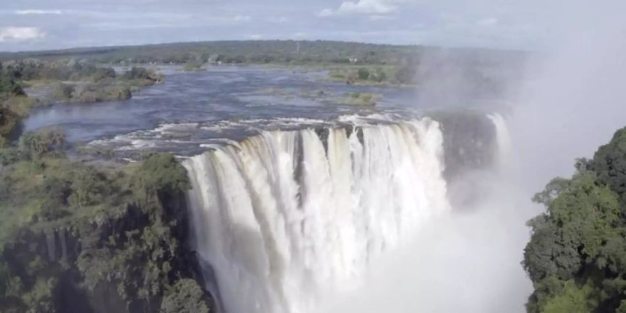 Viel Wasser fliesst durch die Victoriafälle. Die angeblich ausgetrockneten Victoria-Wasserfälle werden von Wasser überströmt, doch der Tourismus bleibt wegen der Pandemie aus. Foto: Columbus S. Mavhunga/dpa