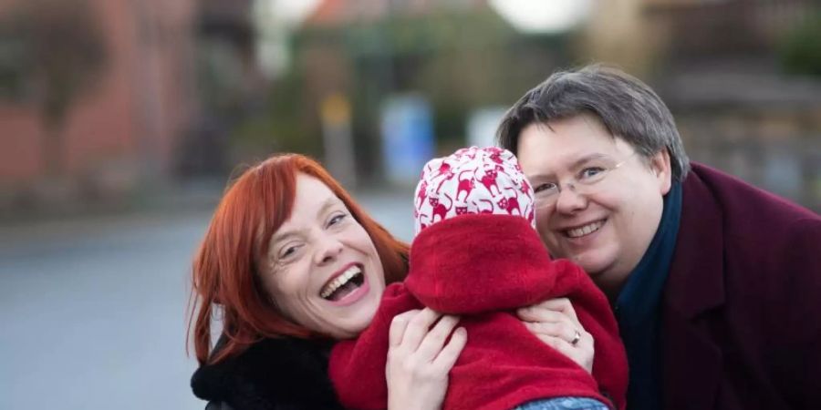 Gesa Teichert-Akkermann (l) und Verena Akkermann mit ihrer Tochter Paula (11 Monate alt). Familie Akkermann will über Familiengerichte eine Gleichstellung mit heterosexuellen Paaren bei der Elternschaft erreichen. Foto: Julian Stratenschulte/dpa