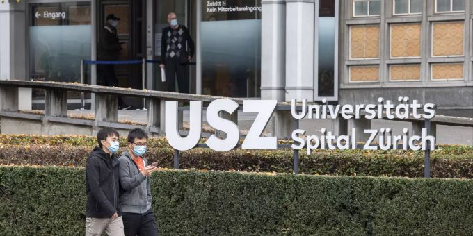 Menschen mit Atemschutzmasken bewegen sich vor dem Haupteingang vom Universitäts Spital Zürich, aufgenommen am Dienstag, 10. November 2020 in Zürich. Universitätsspital Zürich coronavirus