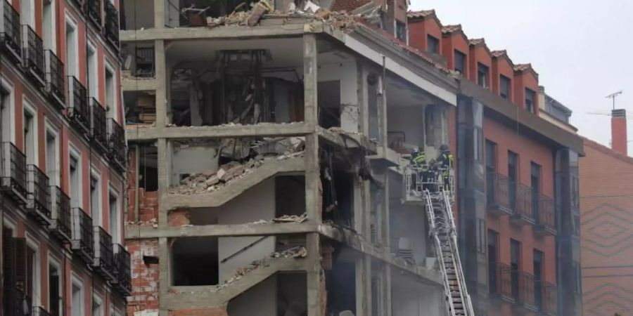 Feuerwehrleute arbeiten nach der schweren Explosion an dem beschädigten Gebäude in Madrids Toledo Strasse. Foto: Manu Fernandez/AP/dpa