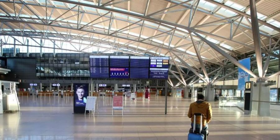 Ein gestrandeter spanischer Fluggast in dem ansonsten fast menschenleeren Terminal 1 am Flughafen Hamburg. Foto: Bodo Marks/dpa