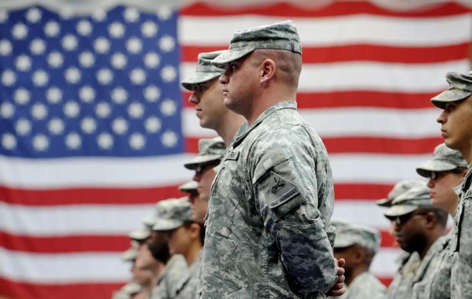 US-Soldaten stehen vor einer US-Flagge. Donald Trump zieht 12'000 Soldaten ab. (Symbolbild) donald trump