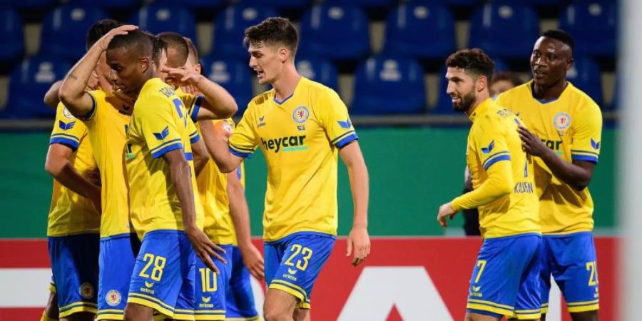 Die Spieler von Eintracht Braunschweig feiern das Tor zum 5:3 gegen Hertha BSC. Foto: Swen Pförtner/dpa