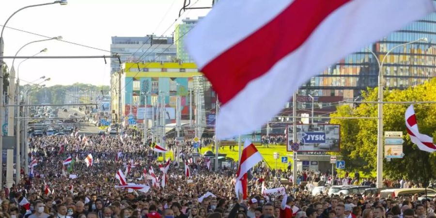 Demonstranten mit alten belarussischen Nationalflaggen gehen nach einer Kundgebung der Opposition durch Minsk, um gegen die offiziellen Ergebnisse der Präsidentschaftswahlen zu protestieren. Foto: Uncredited/TUT.by/dpa