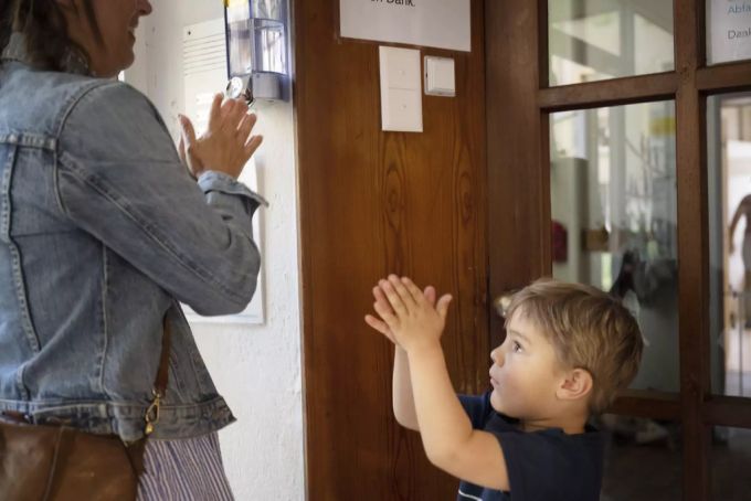 Mutter und Sohn desinfizieren am Eingang einer Kindertagesstätte die Hände vor dem Betreten, fotografiert 17. April 2020. Kita desinfizieren Coronavirus
