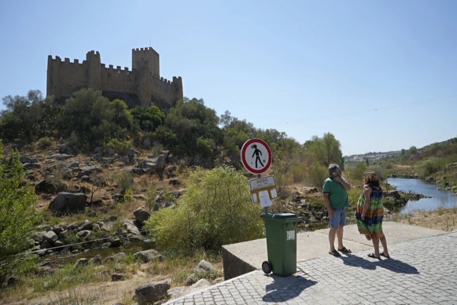 Ein Schild am Ufer des Tejo warnt die Menschen davor, zu Fuss zur Insel der Burg Almourol in Vila Nova da Barquinha, Portugal, zu gehen, Donnerstag, 11. August 2022. Seit Anfang 2022 sieht die Insel von einer Seite eher wie eine Halbinsel aus, da der Pegel des Flusses aufgrund der anhaltenden Dürre sinkt