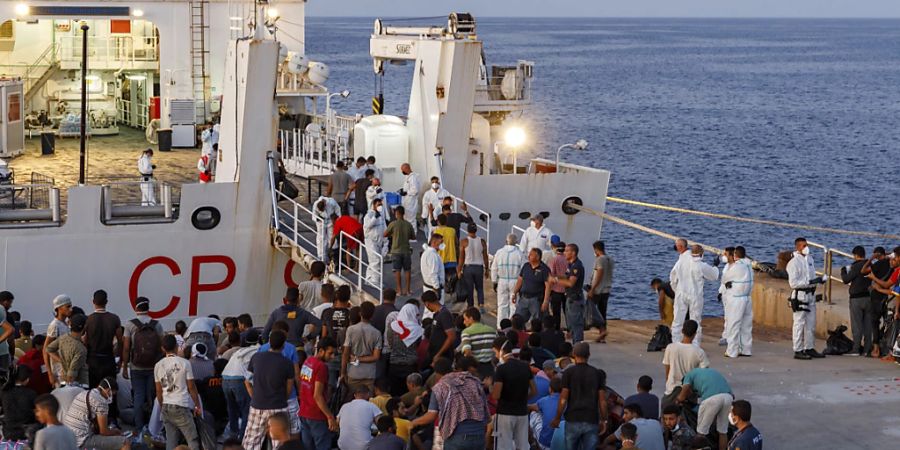 ARCHIV - Migranten warten an Bord eines Schiffes der italienischen Küstenwache auf der sizilianischen Insel Lampedusa. Foto: David Lohmueller/AP/dpa