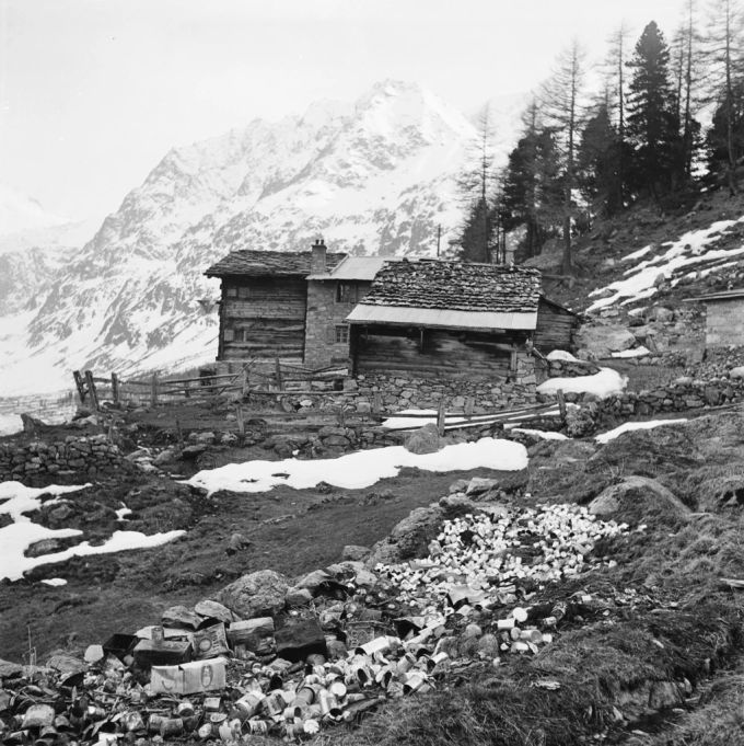 Konservenbüchsen liegen vor einer Alphütte im Wallis, aufgenommen 1946. sac hütte abfall