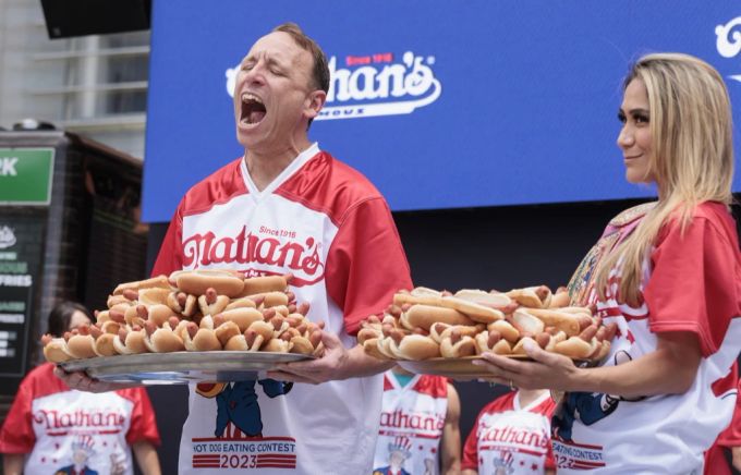Die Spitzenkandidaten Joey Chestnut (L) und Miki Sudo (R) posieren mit Tellern voller Hot Dogs während der Wiegezeremonie. Amerika