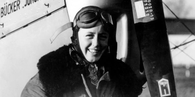 Lächelnd steht Beate Uhse in Fliegermontur vor einem Flugzeug. Beate Uhse war eine der bekanntesten deutschen Frauen des vergangenen Jahrhunderts. 100 Jahre Beate Uhse