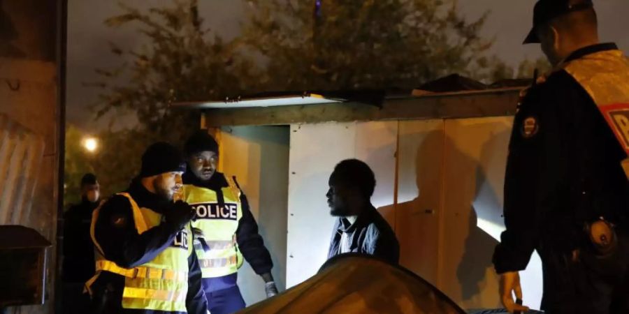 Einsatz im Flüchtlingscamp: Momentaufnahme aus dem Pariser Vorort Saint-Denis. Foto: Francois Mori/AP/dpa