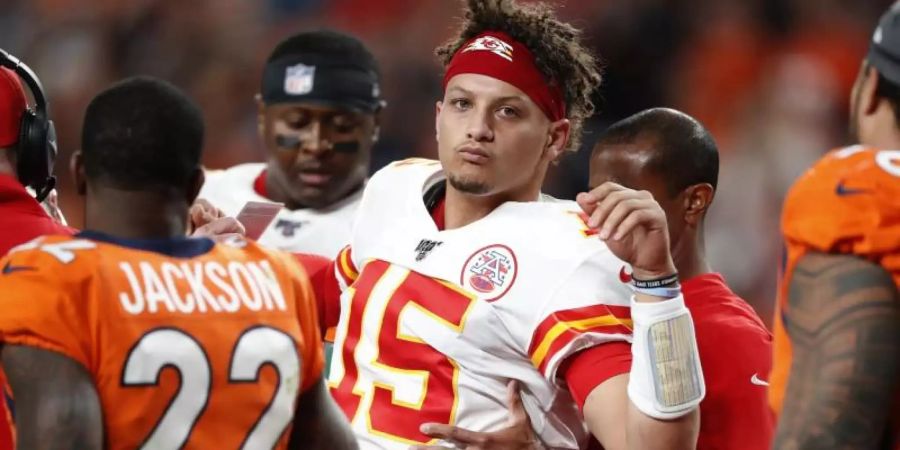 Quarterback Patrick Mahomes (M.) von den Kansas City Chiefs wird geholfen, das Feld zu verlassen. Foto: David Zalubowski/AP/dpa