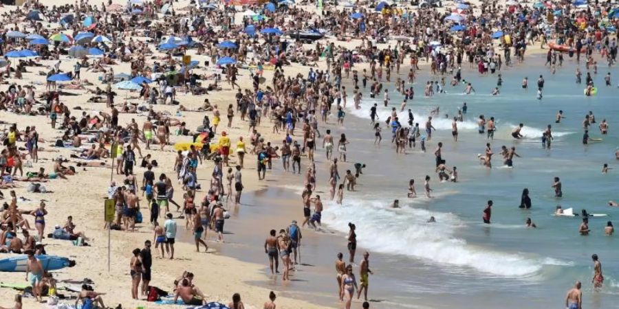 Strandbesucher liegen am Bondi Beach und geniessen das sonnige Wetter. Foto: Mick Tsikas/AAP/dpa