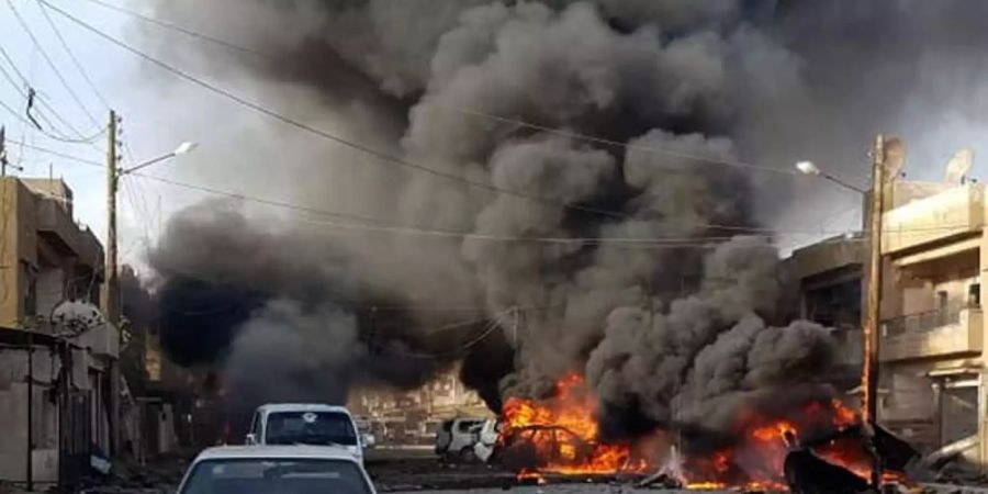 Nach einer Explosion brennen mehrere Autos in einer Strasse in Qamischli im syrisch-türkischen Grenzgebiet. Foto: -/ANHA/AP/dpa