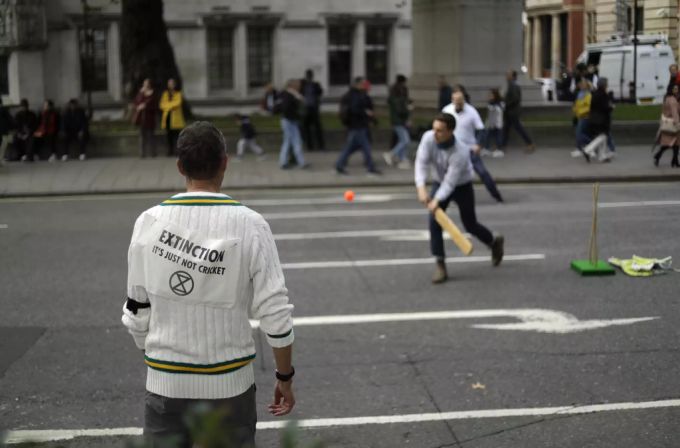 Aktivisten von Extinction spielen im Oktober 2019 Cricket in Parliament Square in London. Extinction Rebellion